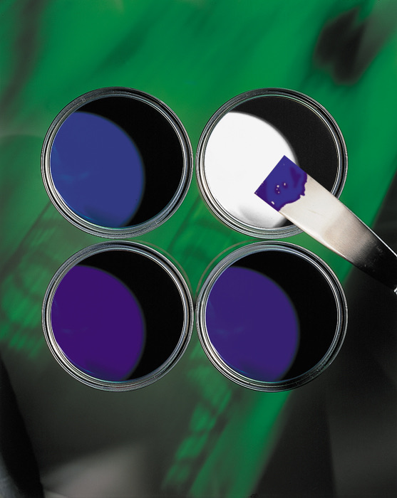 Four open pots of blue and violet paint viewed from above
