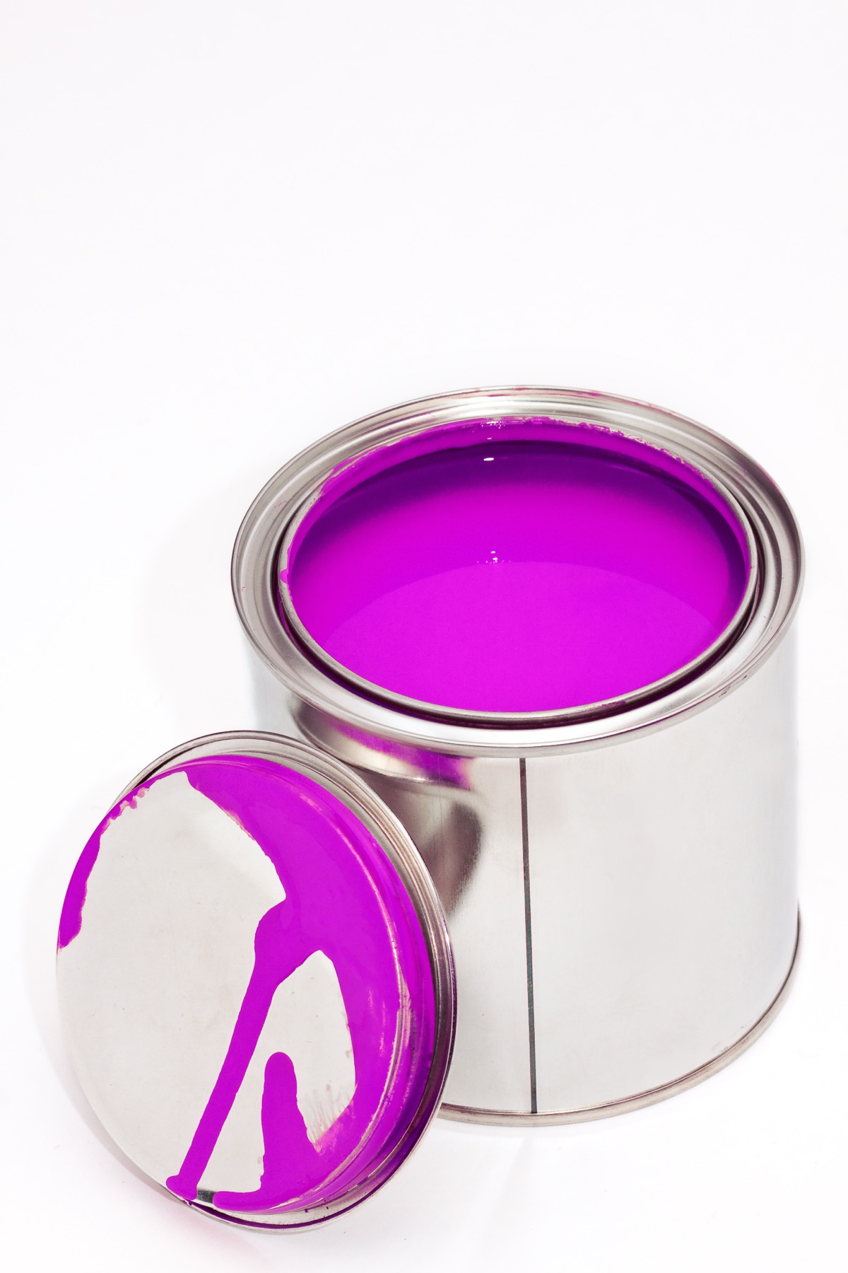 Open tin of vivid pink pigment paste with its lid resting alongside